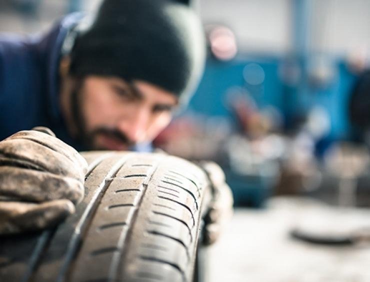 um homem que trabalha com um pneu numa garagem