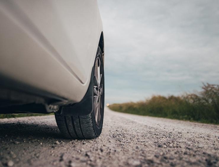 um carro branco estacionado na berma de uma estrada